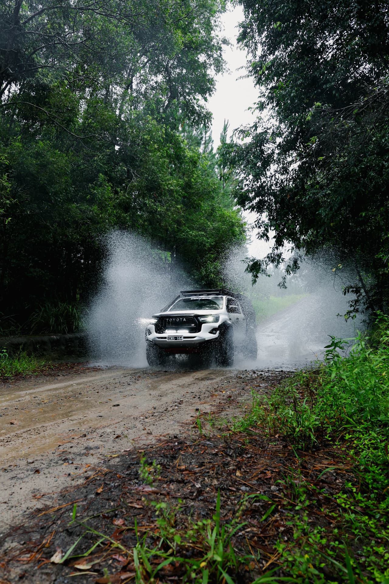 HiLux mid water crossing with spray either side