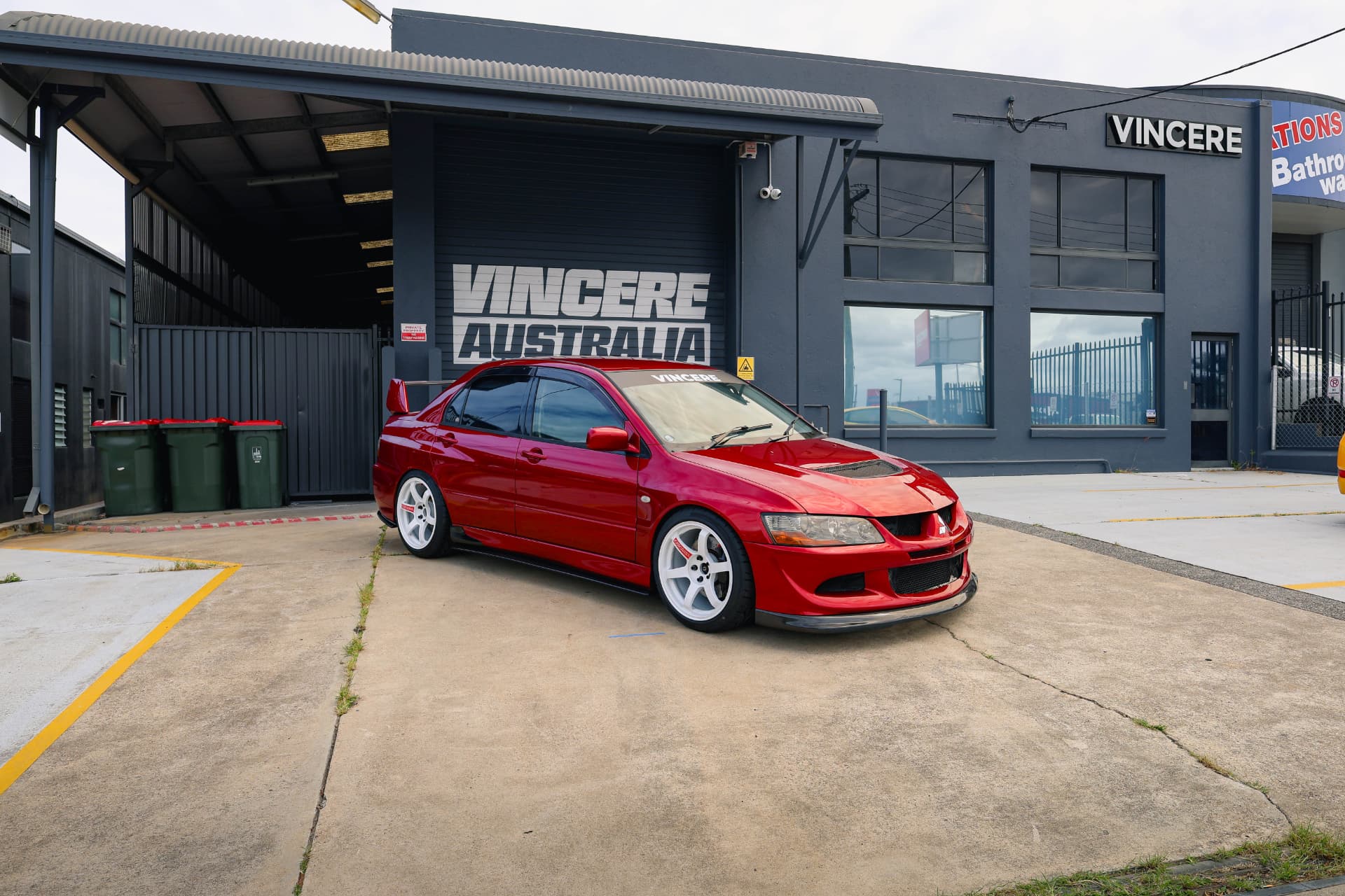 Red Mitsubishi Evo VIII outside a workshop