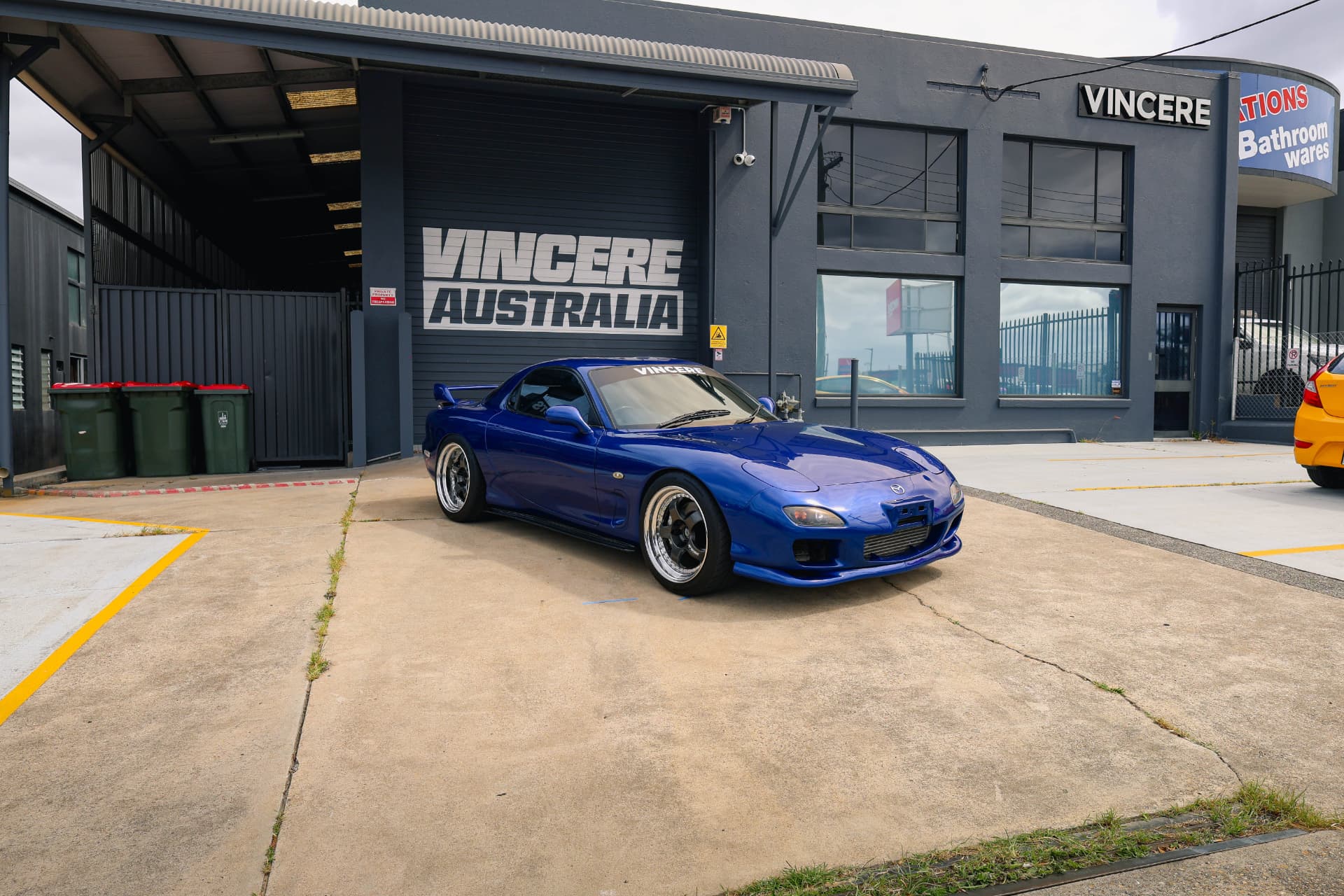 Blue Mazda RX-7 FD outside a workshop