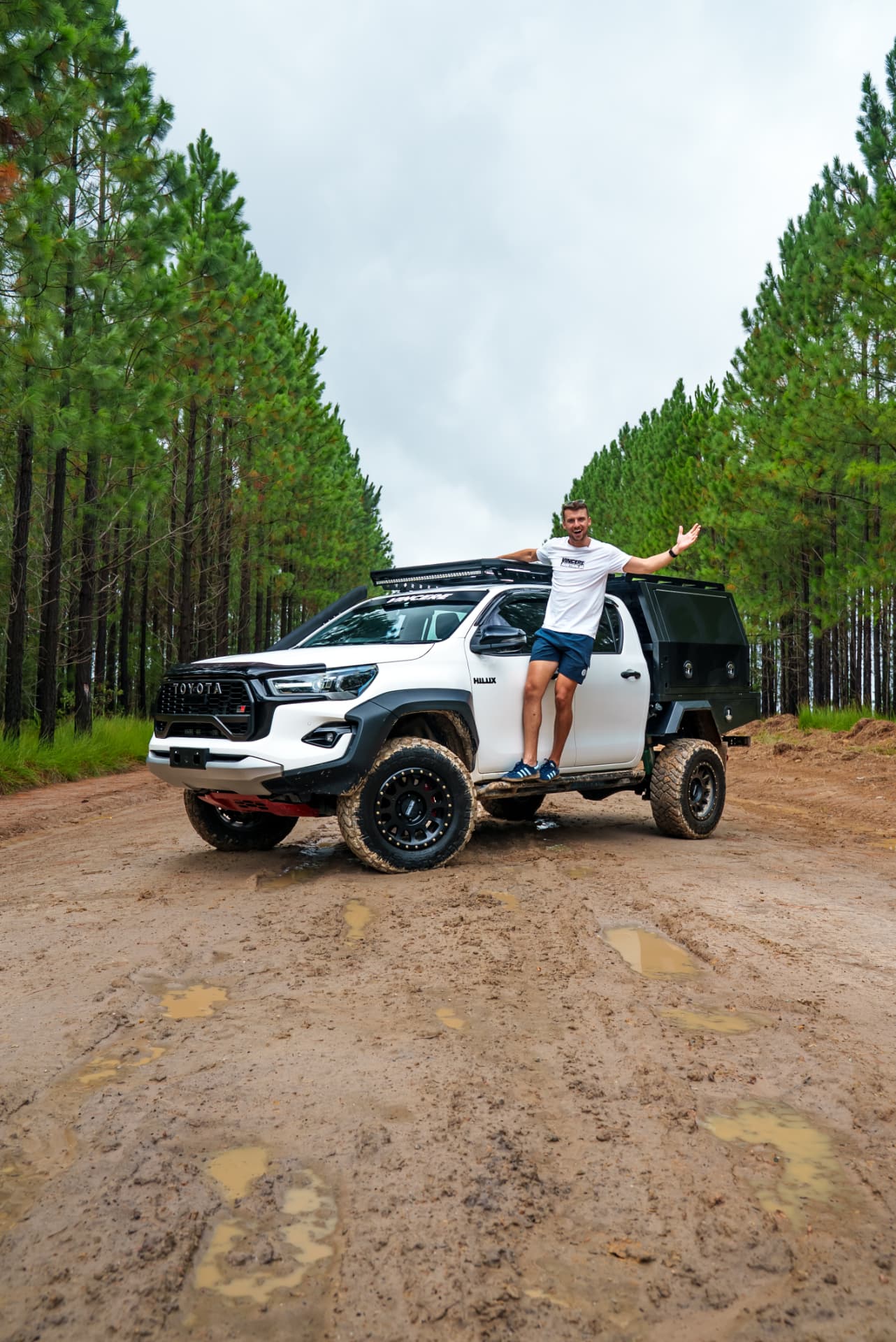 Owner standing on the sill of a HiLux touring rig