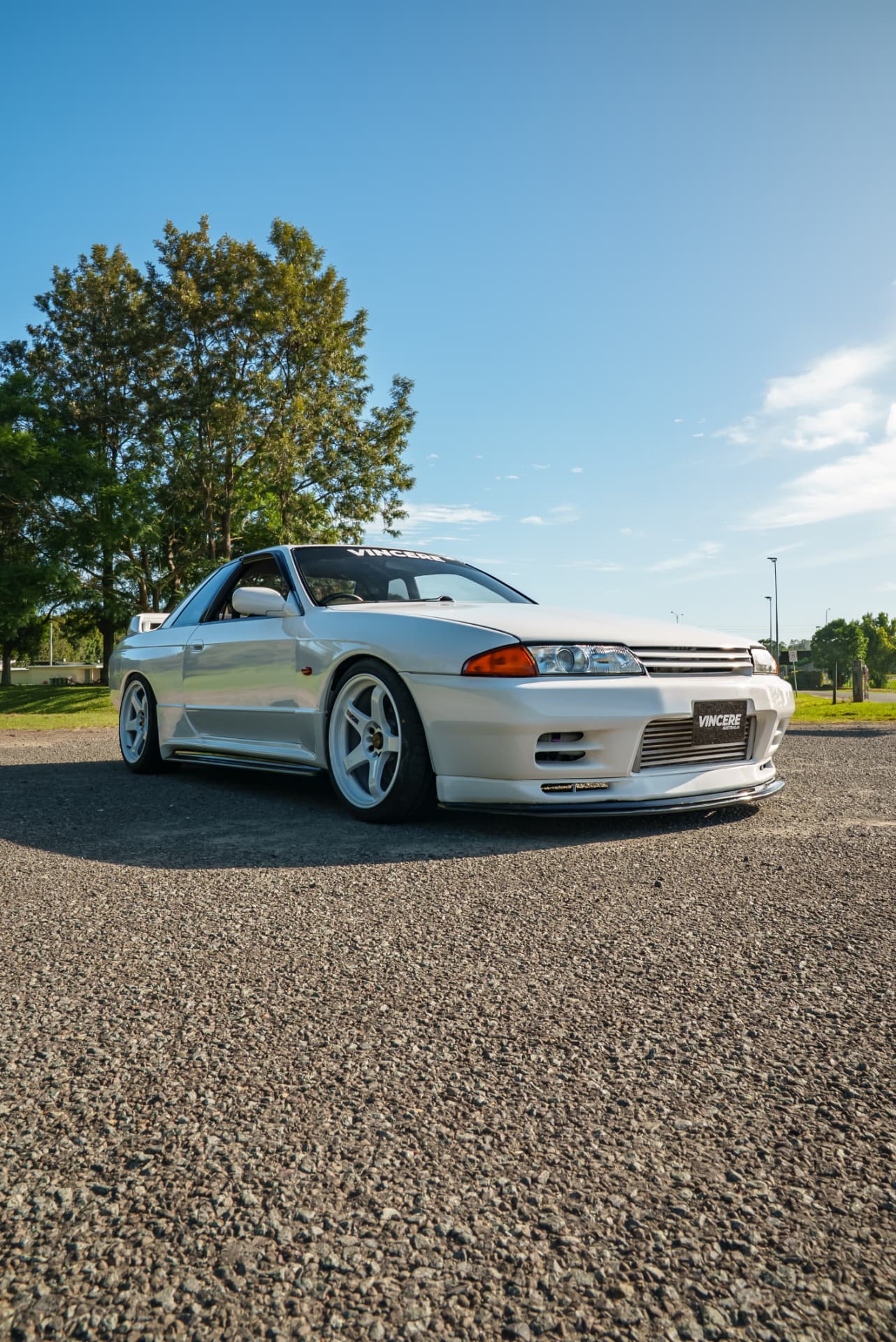 White Nissan Skyline R32 GT-R on gravel at golden hour