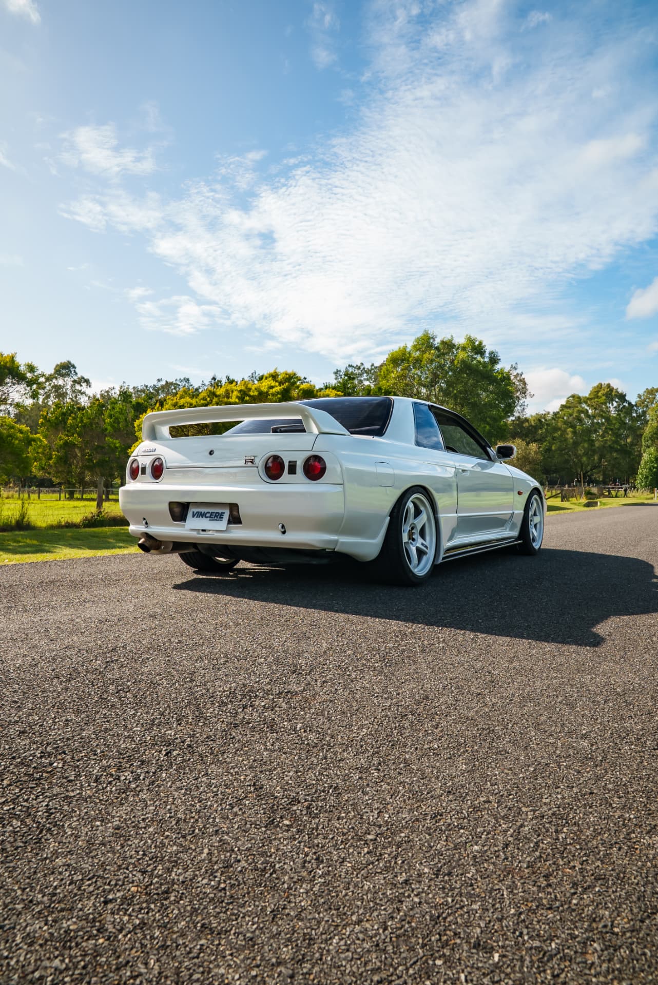 Rear three-quarter of a white R32 GT-R on a country road
