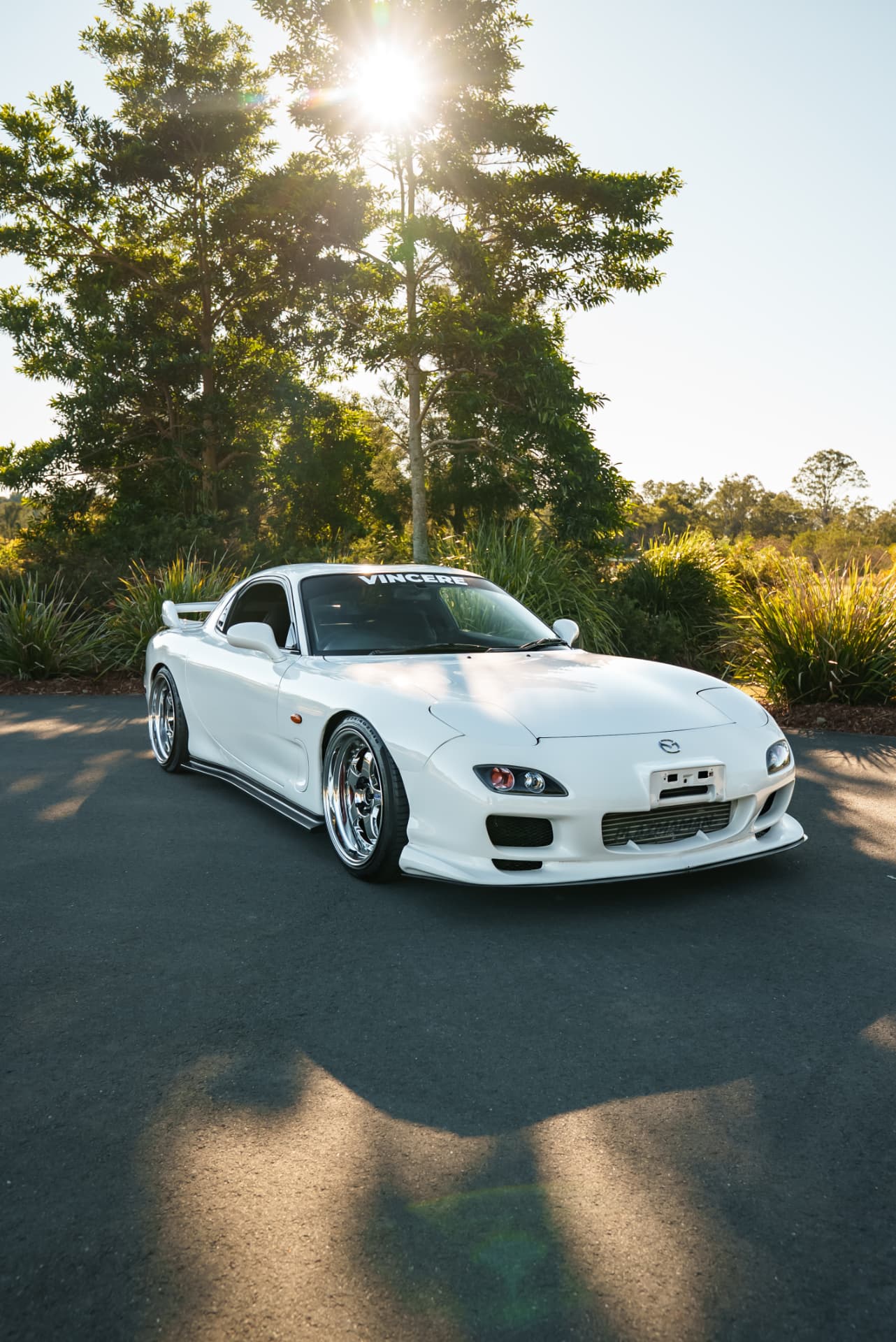 White Mazda RX-7 FD backlit by low sun