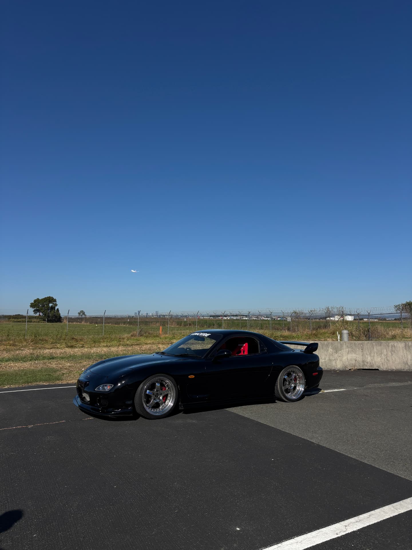 Black Mazda RX-7 FD on an airport-side road