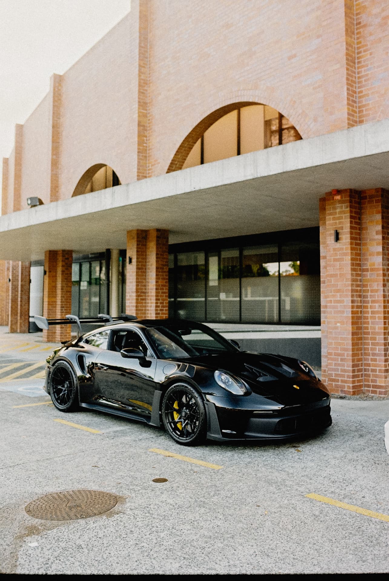 Black Porsche 911 GT3 RS parked beneath brick arches