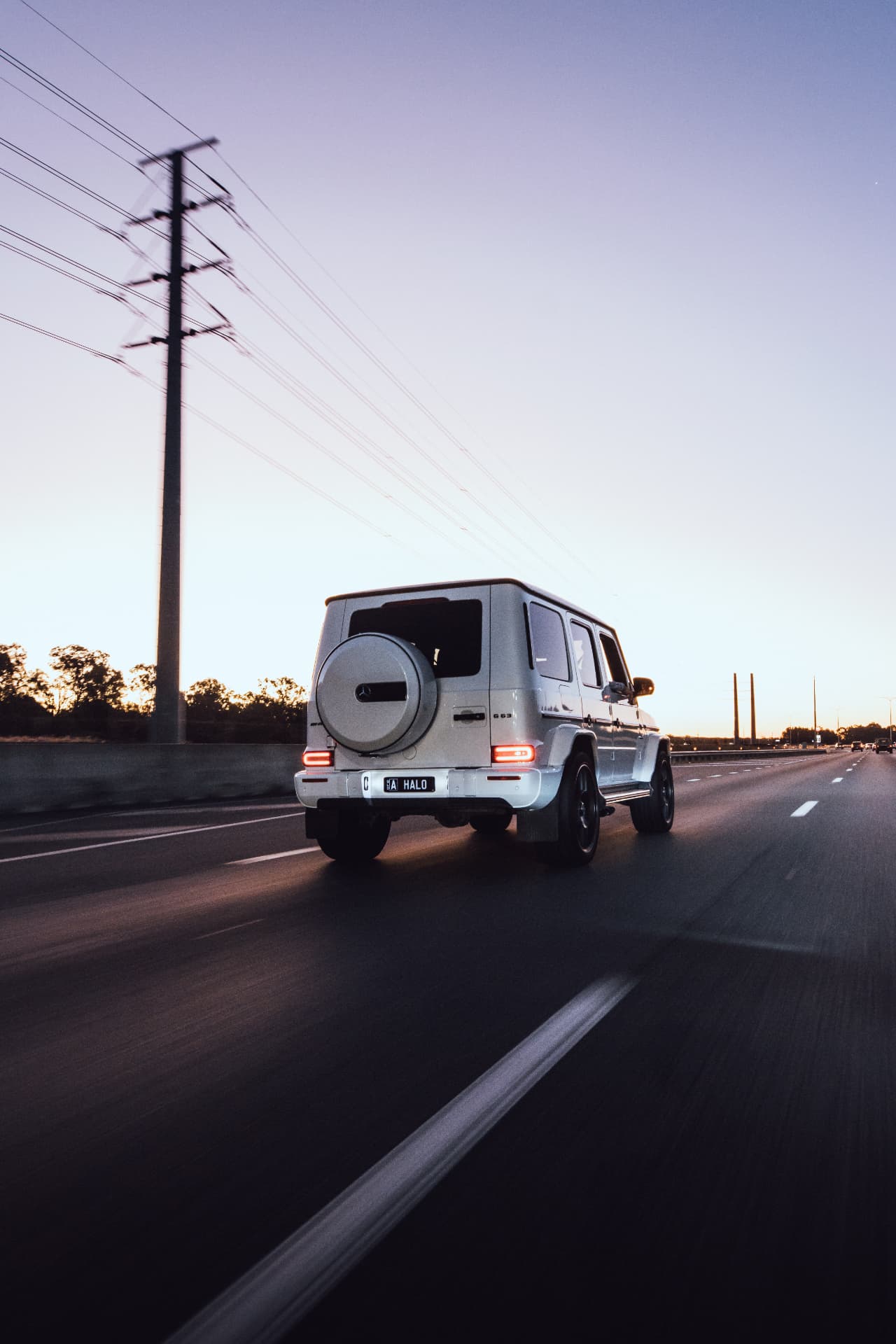 Rear tracking shot of a white G63 at sunset