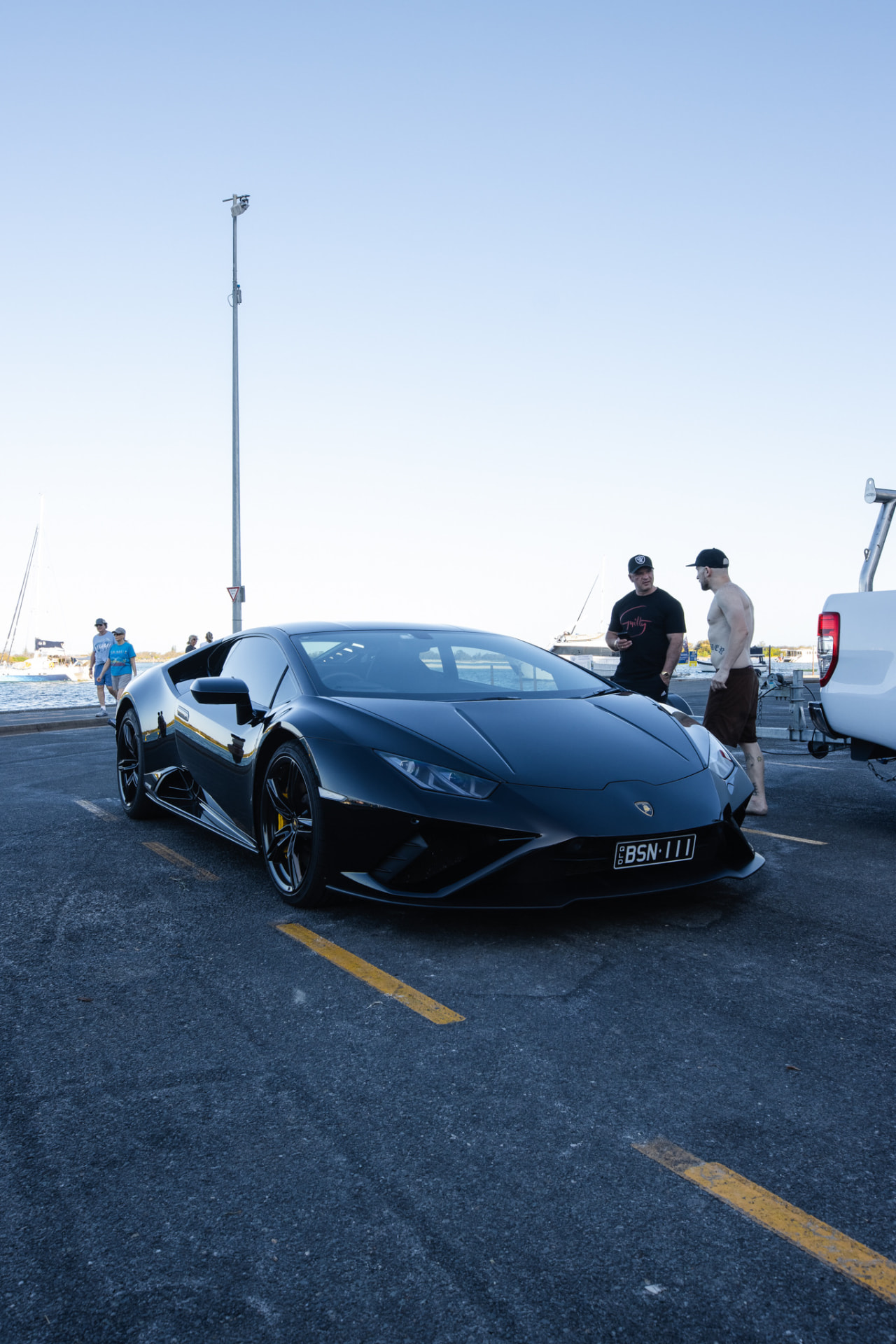 Matte black Lamborghini Huracan at a marina carpark
