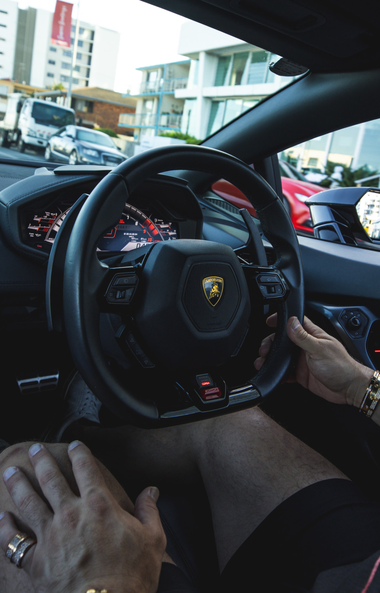 Driver's view of a Lamborghini Huracan cockpit in traffic