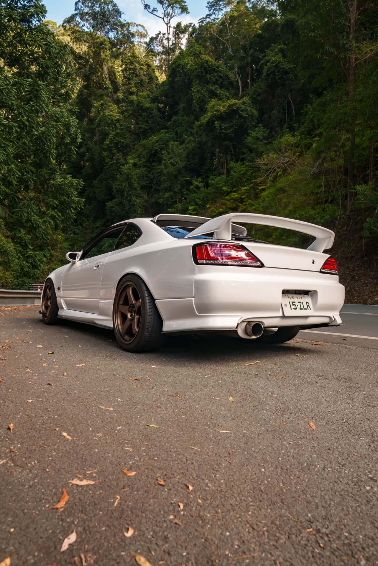 Rear of a white Nissan Silvia S15 on a forest road