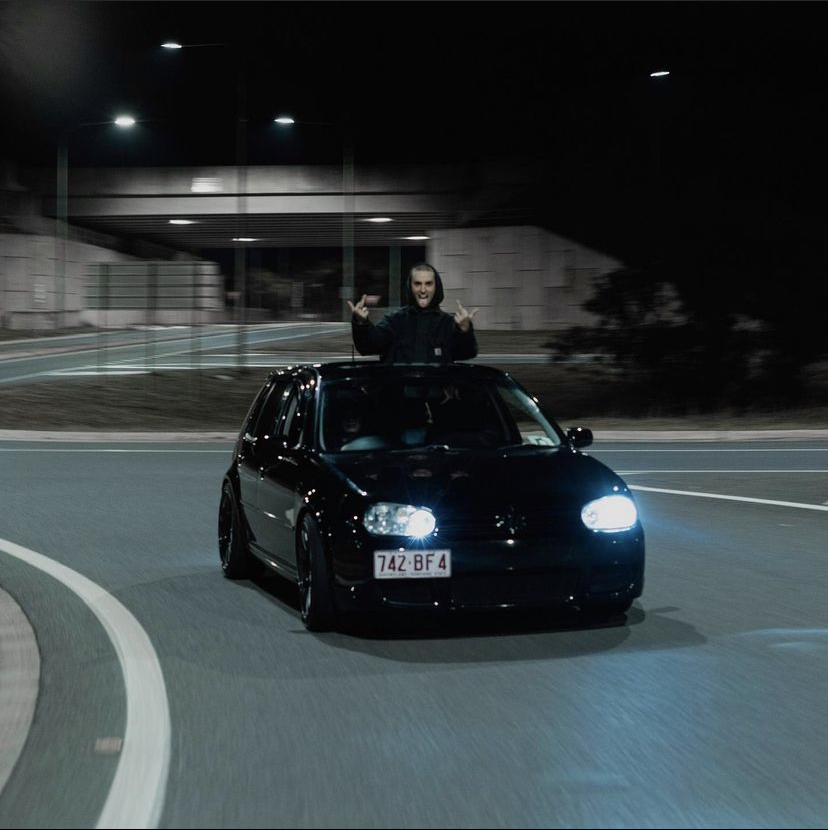 Black Golf rolling at night with the subject out the sunroof