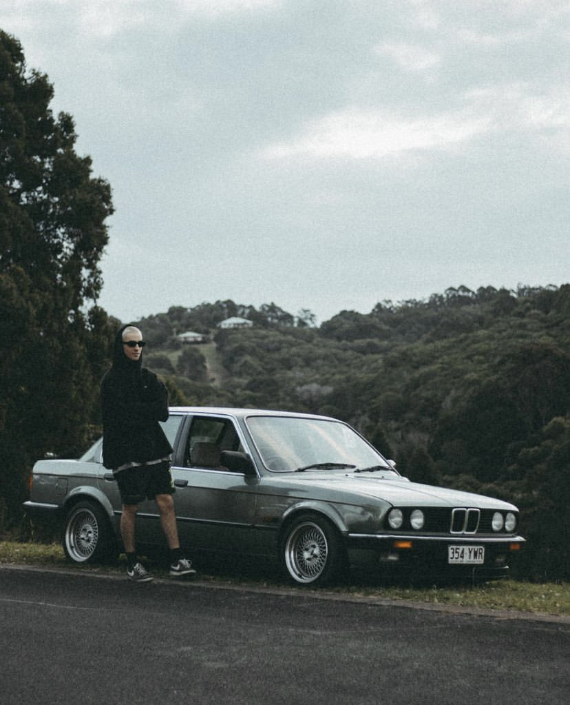 BMW E30 parked at a hinterland lookout with the owner